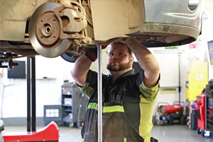 Mechanic working at a brake disc under a car