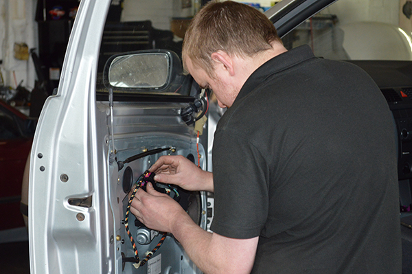 Mechanic working on wiring inside a car door