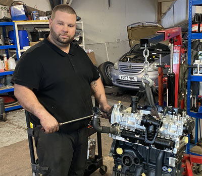 Mechanic with an engine on a stand