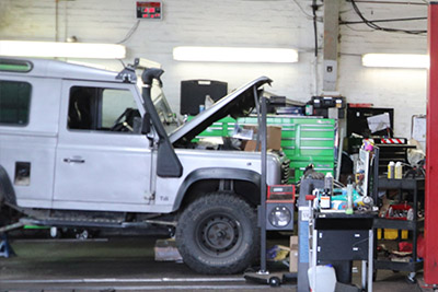 Land Rover Defender with its bonnet up in the workshop