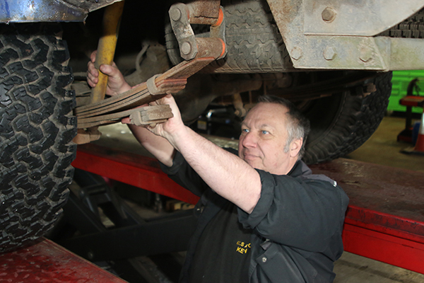 Mechanic working on a Land Rover leaf spring