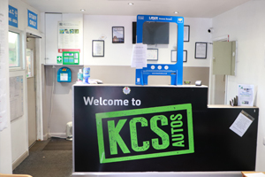 The reception desk with the Welcome to KCS Autos sign