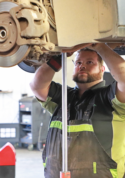Mechanic working under a raised car